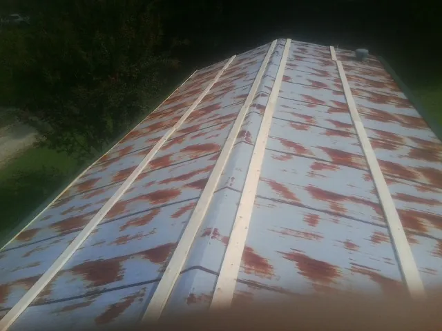 Rusted metal roof panels with new wood purlins before replacement — Storm Damage Roof Repair in Cumberland Furnace by Roofing Brothers