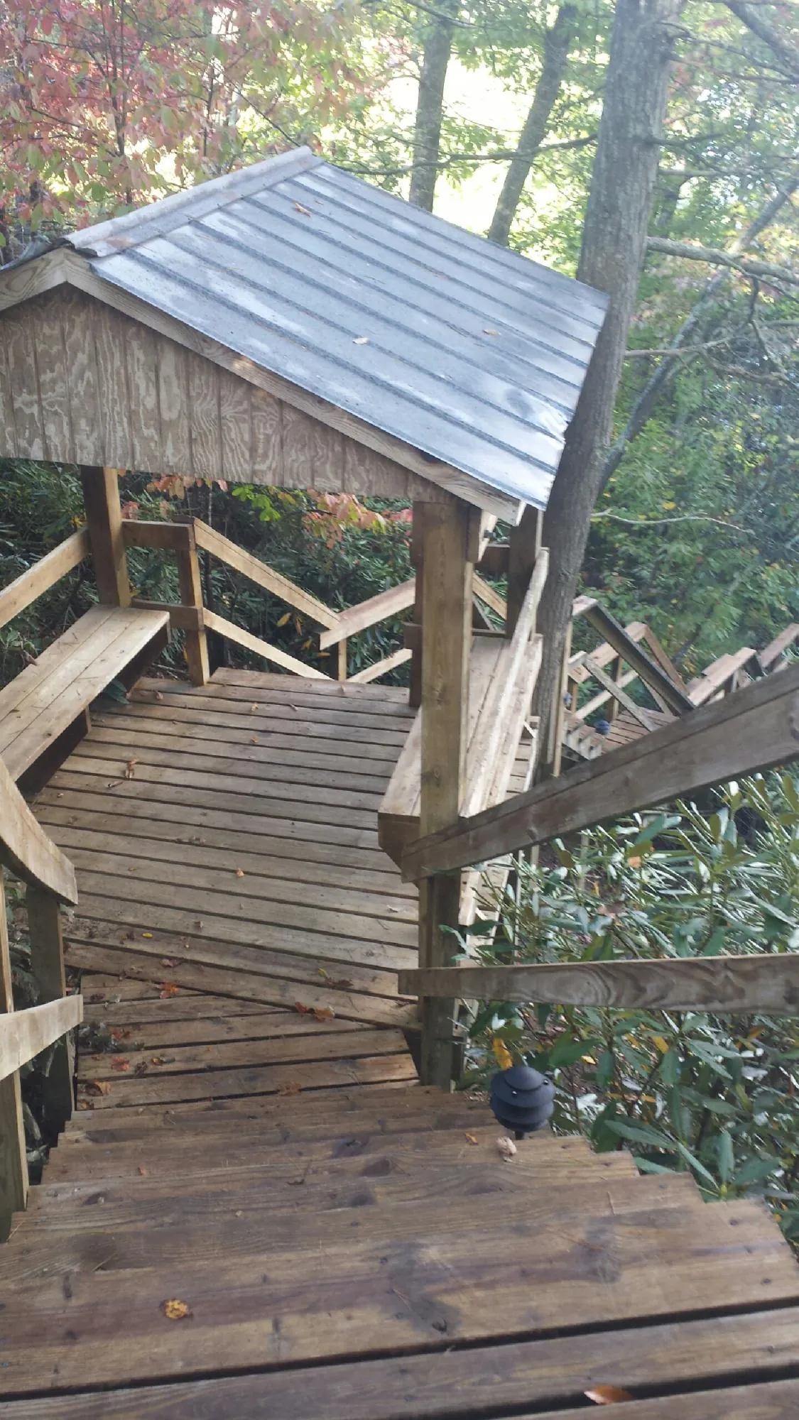 Metal roofed shelter over wooden steps on a wooded walkway — Skylight Repair & Installation work by our crew in Cumberland Furnace