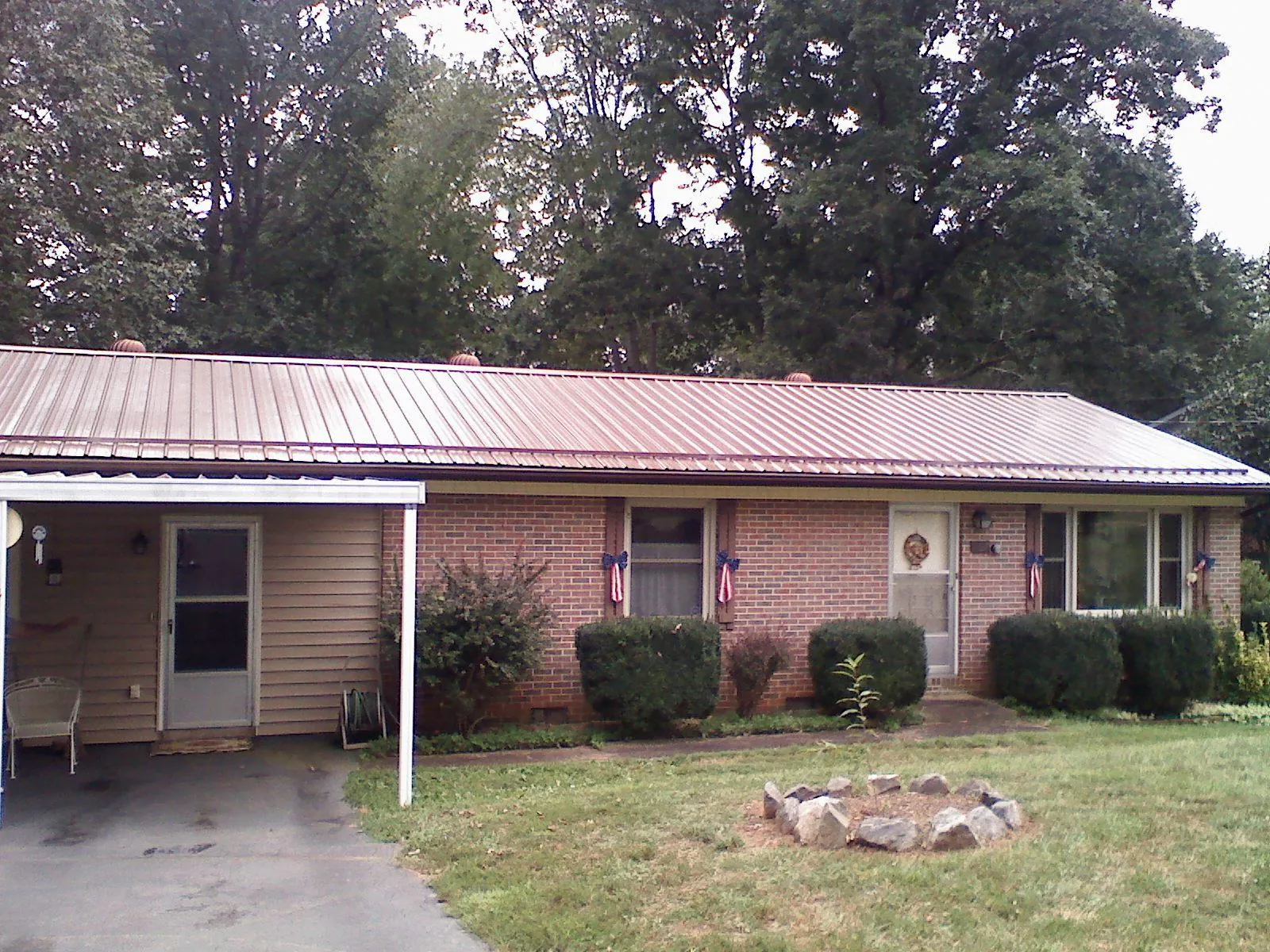 Bronze metal roof and carport on a brick ranch home — Roof Repair work by our crew in Cumberland Furnace